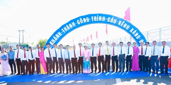Các đại biểu chụp ảnh lưu niệm bên cầu Kênh Xáng Dọc tại lễ khánh thành 