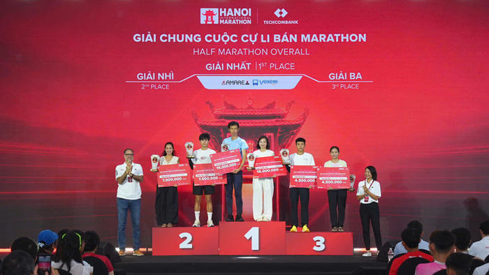 Bà Anh Võ, Tổng Giám đốc công ty Sunrise Events Vietnam (ngoài cùng bên phải) cùng ông Rob Zamacona, Cố vấn cấp cao công ty Sunrise Event Vietnam (ngoài cùng bên trái) trao giải cho top 3 chung cuộc cự ly Bán Marathon.