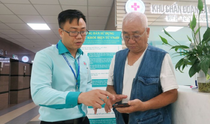 Nhân viên Bệnh viện Nhân dân 115 (TP HCM) hướng dẫn người bệnh sử dụng sổ sức khỏe điện tử VNeID